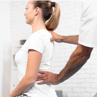 physio performing exercises on the back of a female patient
